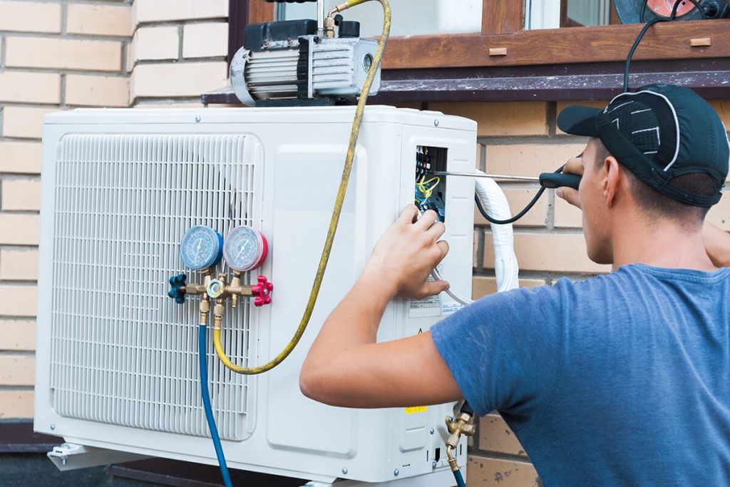 HVAC Technician performing air conditioner maintenance