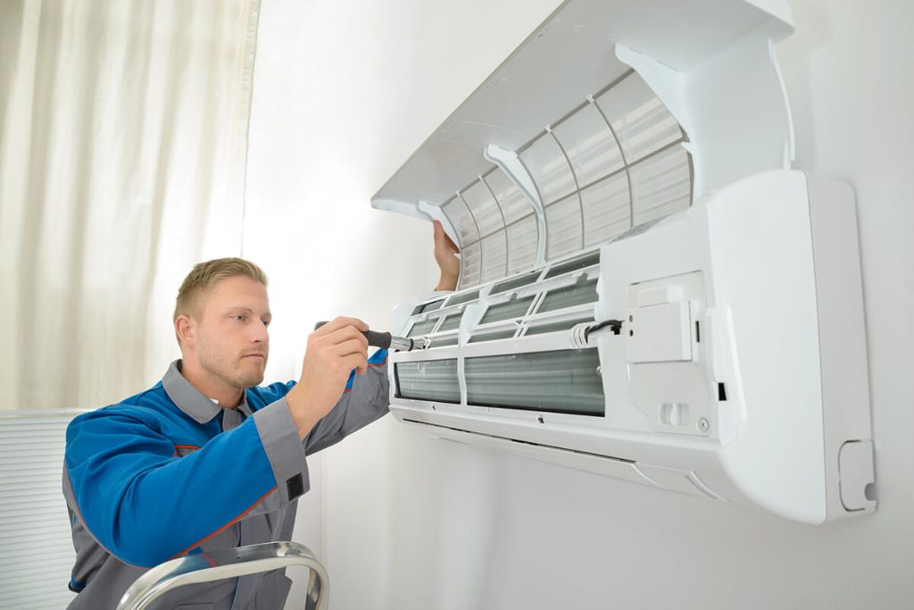 HVAC Technician repairing air conditioning unit