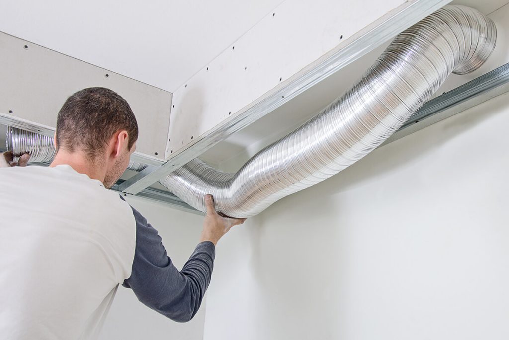 HVAC Technician installing air ducts