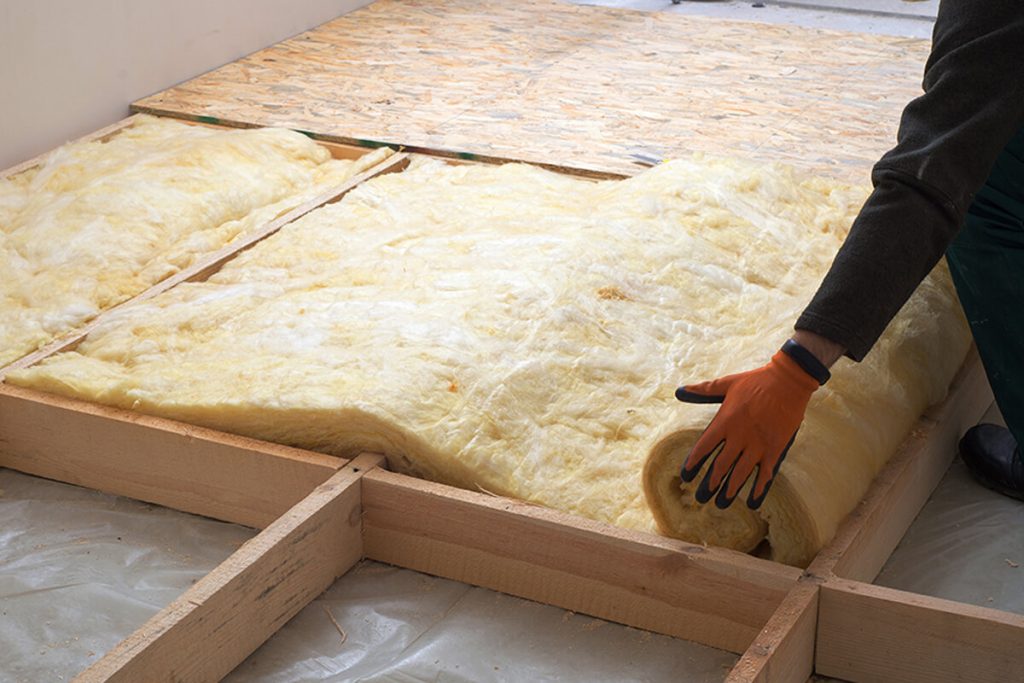 Technician installing new insulation in a home attic